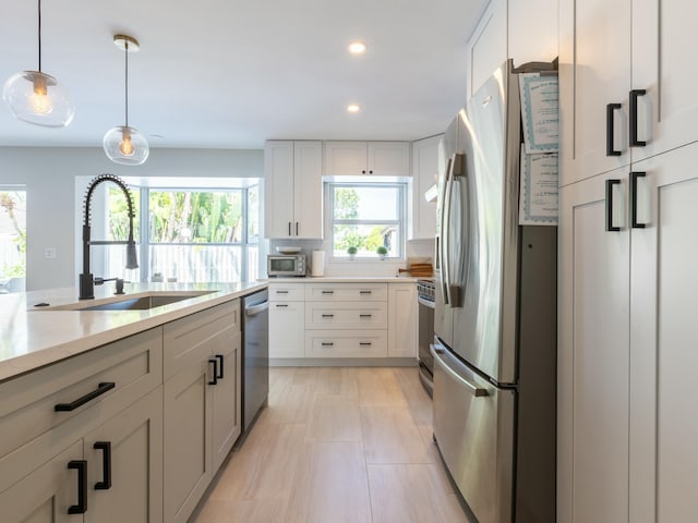 kitchen with recessed lighting, a sink, white cabinetry, pendant lighting, and appliances with stainless steel finishes
