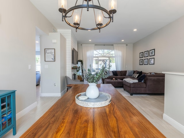 dining area featuring baseboards, an inviting chandelier, light wood-style flooring, and plenty of natural light