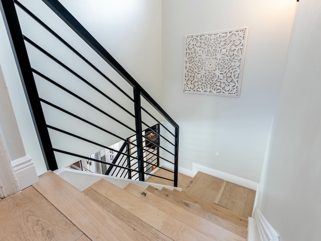 stairway with baseboards and wood finished floors