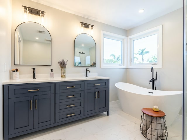 bathroom with a sink, marble finish floor, double vanity, visible vents, and a soaking tub