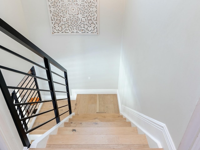 stairway featuring hardwood / wood-style flooring and baseboards