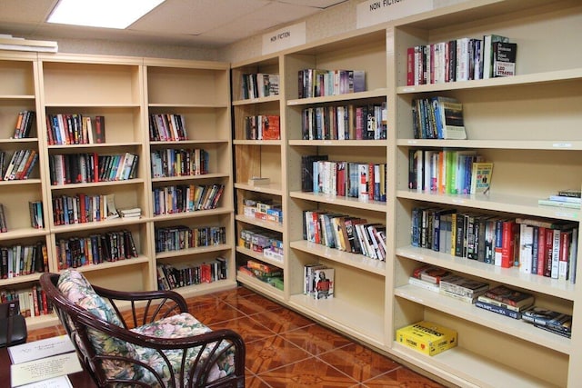 211 Lake Dora Dr, West Palm Beach, FL 33411 - living area with wall of books, dark tile patterned flooring, and a drop ceiling