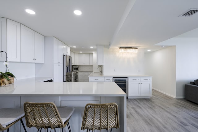 5600 N Flagler Dr Unit 1207, West Palm Beach, FL 33407 - kitchen with baseboards, a peninsula, stainless steel fridge with ice dispenser, and wine cooler