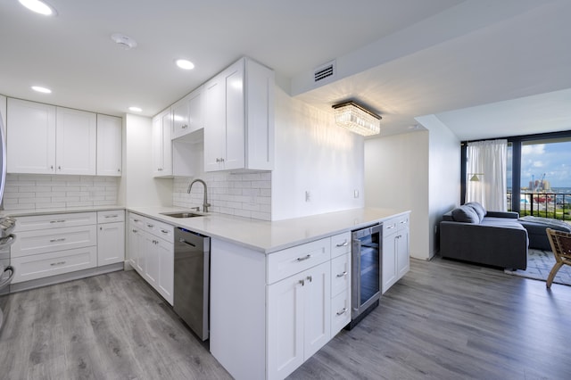 5600 N Flagler Dr Unit 1207, West Palm Beach, FL 33407 - kitchen with stainless steel dishwasher, a sink, visible vents, open floor plan, and wine cooler
