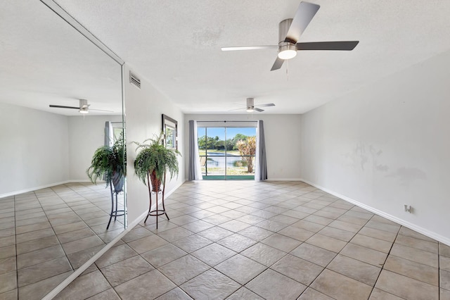 spare room with light tile patterned floors, ceiling fan, and visible vents