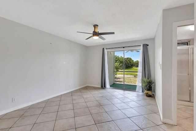 empty room featuring baseboards, ceiling fan, and light tile patterned floors