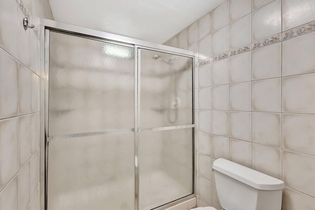 bathroom with a shower stall and toilet
