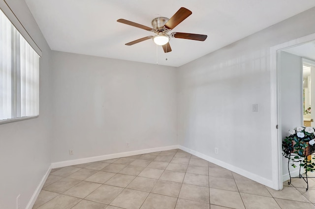 spare room featuring baseboards, a ceiling fan, and light tile patterned flooring