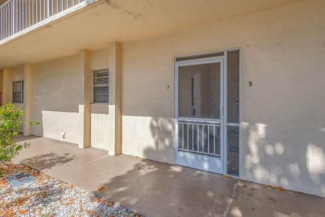 doorway to property featuring a patio and stucco siding
