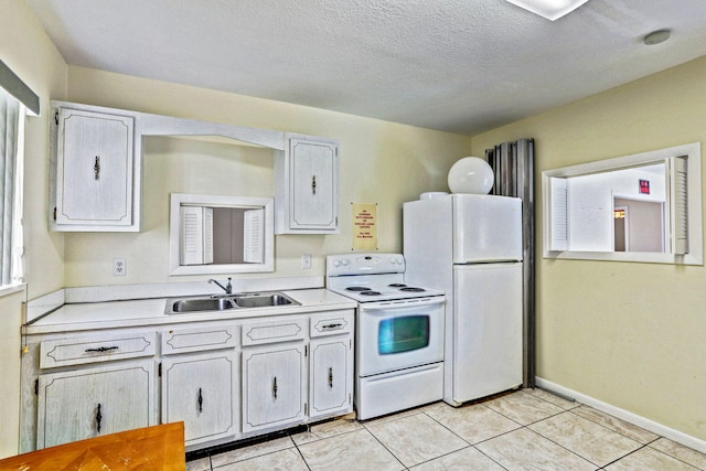 kitchen featuring white appliances, light tile patterned floors, a sink, and light countertops