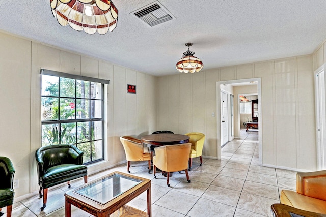 dining space featuring plenty of natural light, a textured ceiling, and visible vents