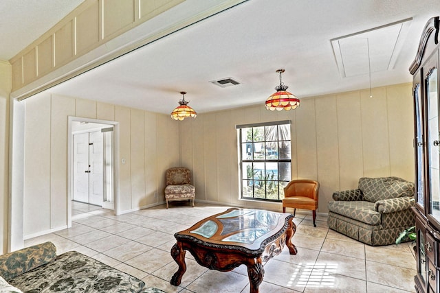 living room with visible vents, attic access, and light tile patterned floors