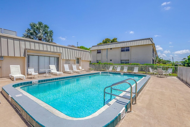 pool with a patio and fence