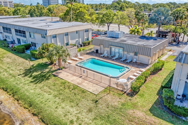 outdoor pool with a patio area, fence, and a yard