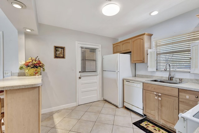 kitchen with light tile patterned flooring, light brown cabinets, white appliances, light countertops, and a sink