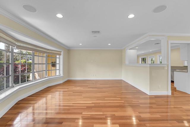 spare room with visible vents, baseboards, light wood-style floors, ornamental molding, and recessed lighting