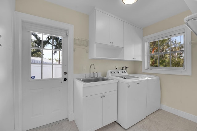 laundry area with a sink, a healthy amount of sunlight, cabinet space, and washer and clothes dryer