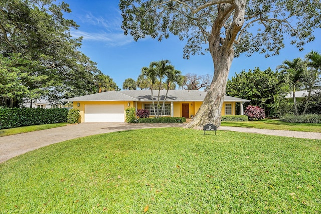 ranch-style house featuring concrete driveway, an attached garage, stucco siding, and a front lawn