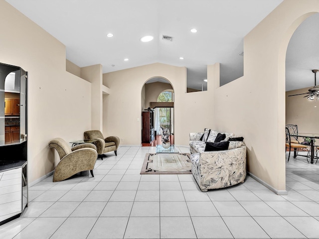 living room with arched walkways, ceiling fan, and light tile patterned floors