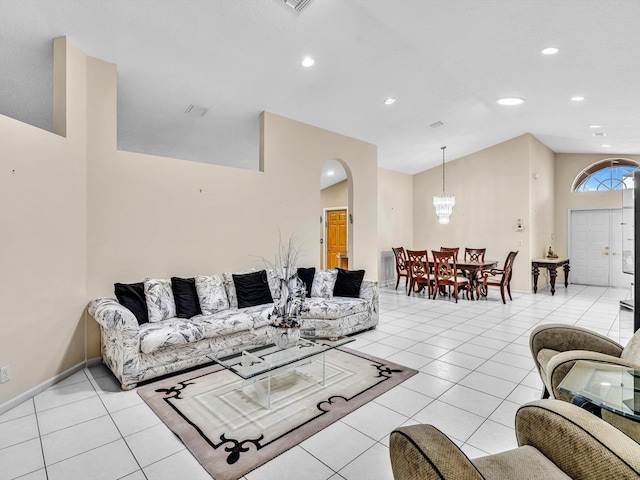 living area with light tile patterned flooring, recessed lighting, a chandelier, arched walkways, and vaulted ceiling