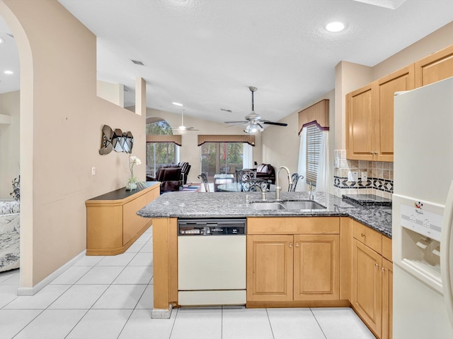 kitchen featuring a peninsula, white appliances, open floor plan, ceiling fan, and a sink