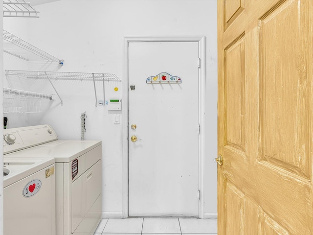 washroom featuring laundry area, washer and clothes dryer, and light tile patterned floors