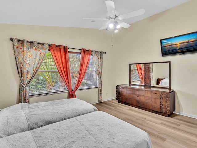 bedroom featuring a ceiling fan, baseboards, vaulted ceiling, and wood finished floors