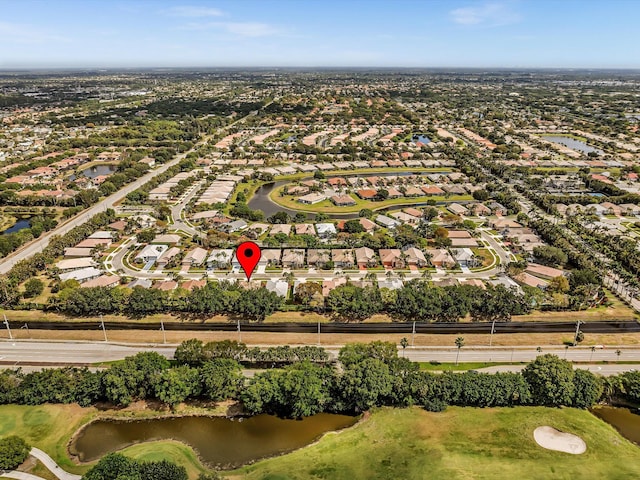 drone / aerial view featuring a water view, golf course view, and a residential view