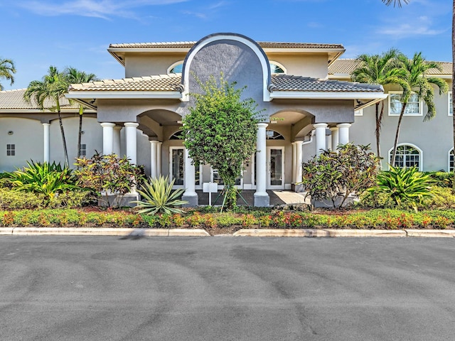 mediterranean / spanish home with stucco siding and a tile roof
