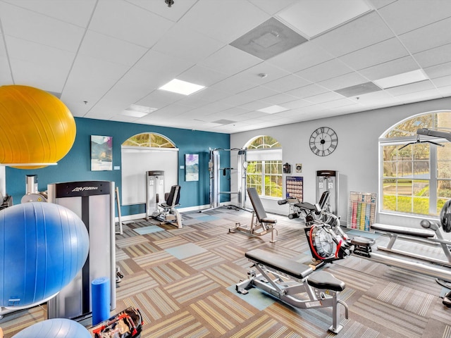 exercise room featuring baseboards, carpet, and a drop ceiling