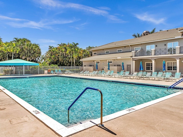 community pool with fence and a patio area