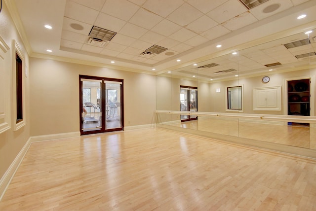 exercise area with crown molding, a drop ceiling, wood finished floors, and baseboards