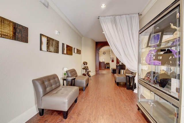 living area with wood finished floors, recessed lighting, arched walkways, and baseboards