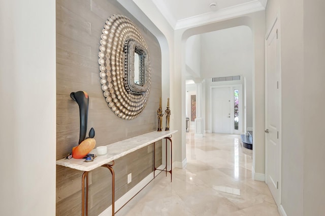 hallway with ornamental molding, marble finish floor, and baseboards