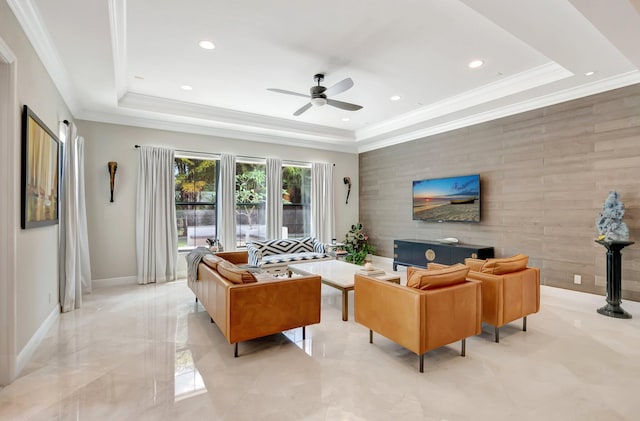 living area with recessed lighting, marble finish floor, an accent wall, a ceiling fan, and a tray ceiling