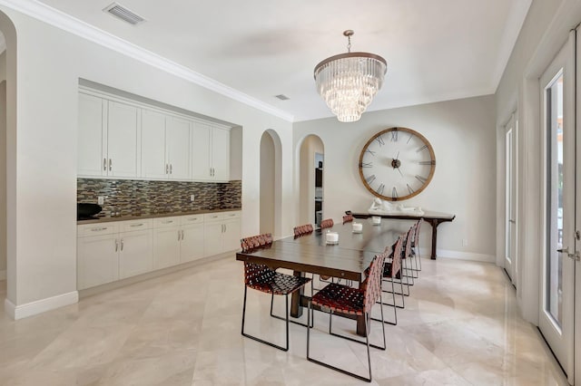 dining area with crown molding, arched walkways, visible vents, and a chandelier