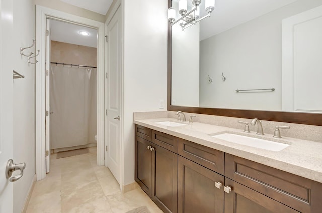 full bathroom with double vanity, toilet, baseboards, and a sink