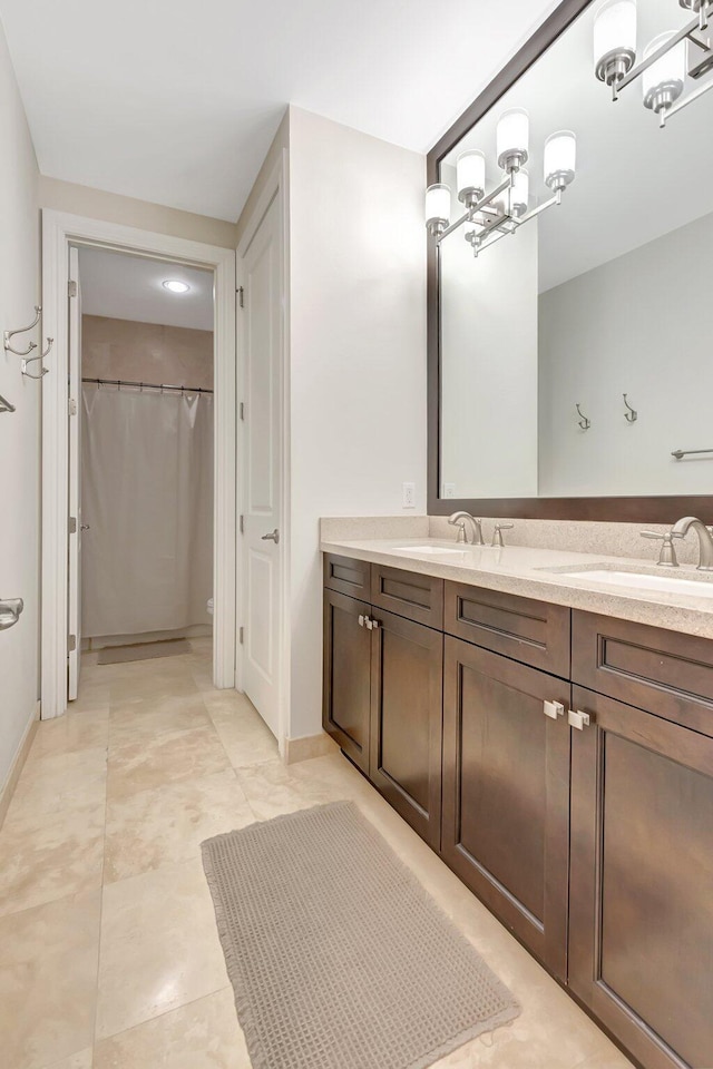 bathroom with an inviting chandelier, vanity, a shower with shower curtain, and baseboards