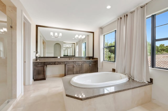 full bathroom featuring baseboards, walk in shower, a garden tub, and vanity