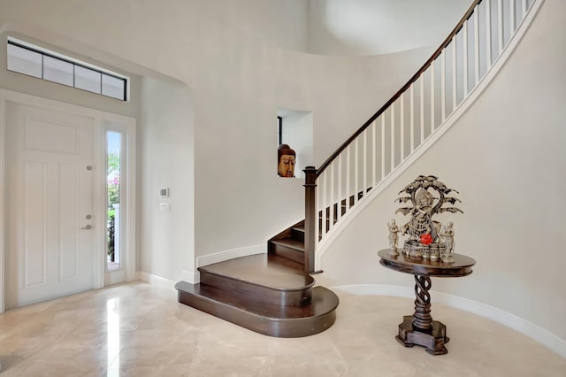 foyer entrance with a high ceiling and stairway