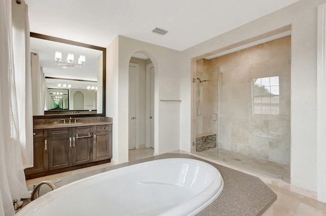 bathroom with a stall shower, visible vents, a washtub, and vanity