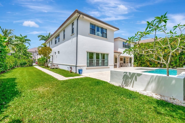 back of property with a patio, stucco siding, a yard, and an outdoor pool