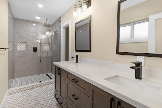 full bath with a sink, a tile shower, recessed lighting, and double vanity