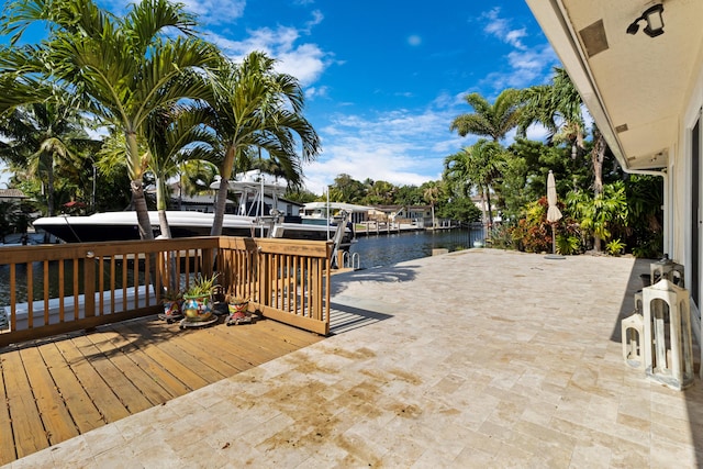 wooden terrace with a water view, a dock, a patio, and boat lift