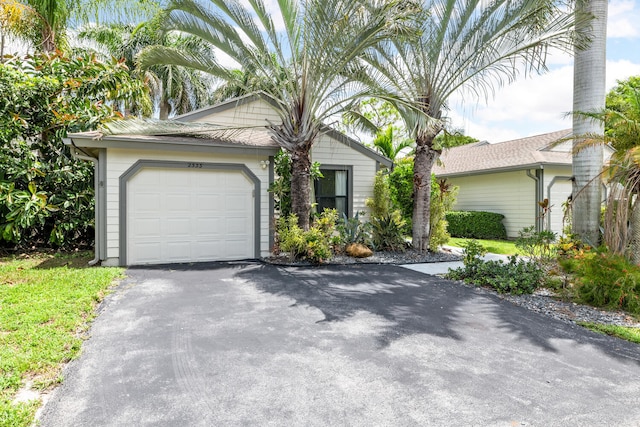 view of front facade featuring an attached garage and aphalt driveway
