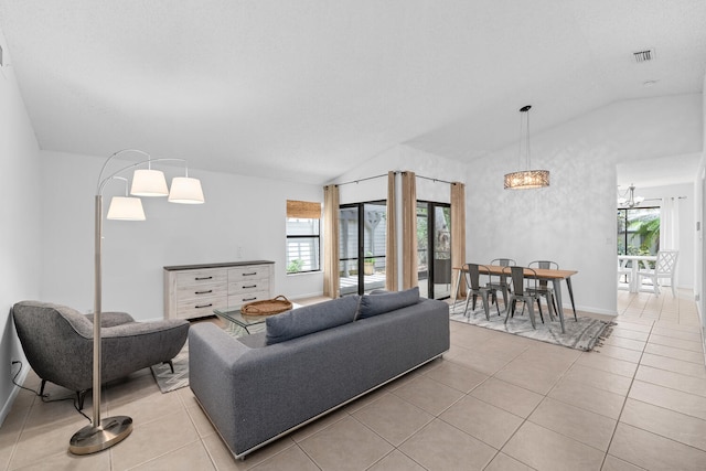 living room featuring an inviting chandelier, light tile patterned floors, visible vents, vaulted ceiling, and baseboards
