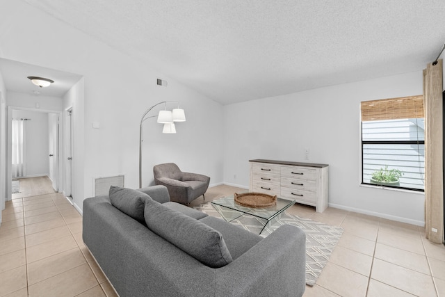 living room featuring visible vents, a textured ceiling, light tile patterned flooring, and lofted ceiling