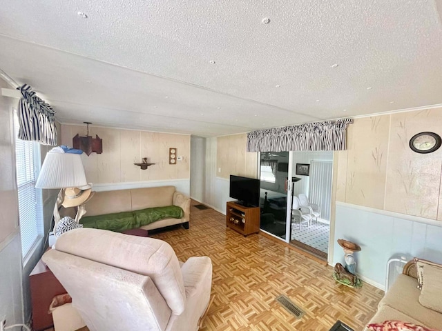 3020 SE 38th Ave, Okeechobee, FL 34974 - living area with wood walls, a textured ceiling, and visible vents