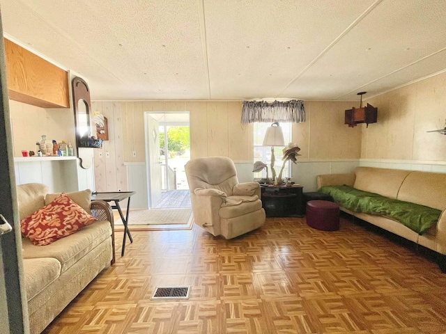 3020 SE 38th Ave, Okeechobee, FL 34974 - living room with wood walls, a textured ceiling, and visible vents