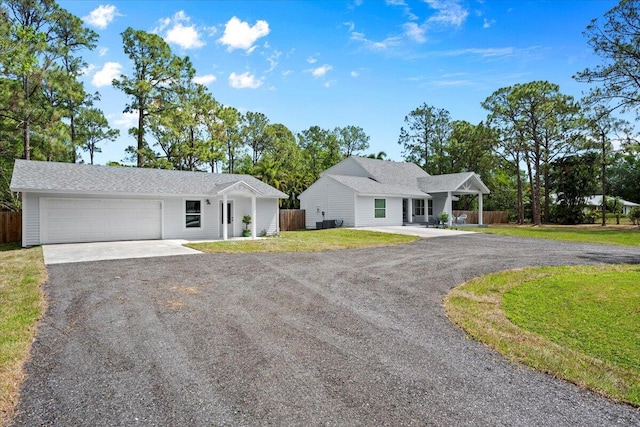 ranch-style home featuring fence, driveway, a front lawn, and a garage